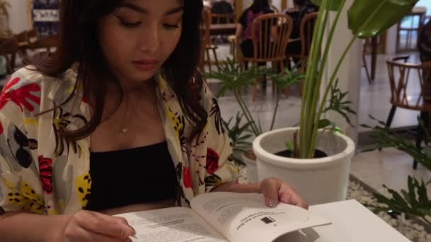 Очаровательная Азиатка Сидит Читает Книгу Ресторане — стоковое видео