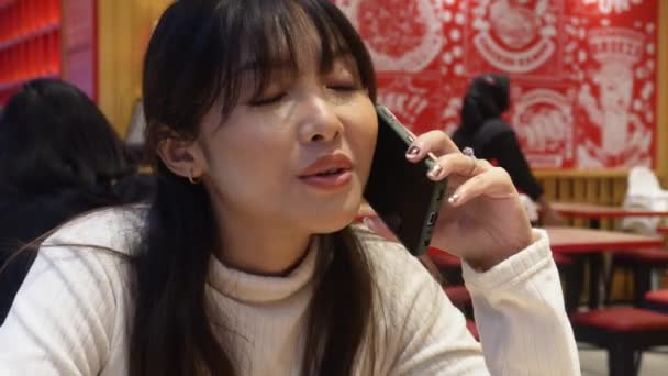 Egy Vonzó Ázsiai Aki Telefonon Beszél Miközben Étteremben Vacsorázik — Stock videók
