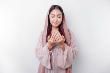 Dini, güzel, Asyalı, başörtüsü takmış, beyaz bir geçmişle Tanrı 'ya dua eden Müslüman bir kız.