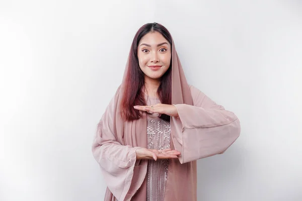 Junge Asiatische Muslimin Mit Isoliertem Hintergrund Hält Imaginären Kopierraum Auf — Stockfoto