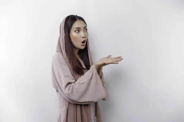 stock image Shocked Asian Muslim woman pointing at the copy space on beside her, isolated by white background