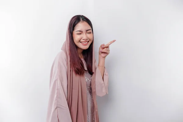 彼女の横にスペースをコピーするために指している間 若いアジアのイスラム教徒の女性笑顔 — ストック写真