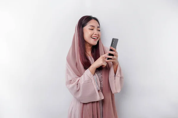 Щаслива Мусульманка Азії Одягнена Хустку Тримаючи Телефон Ізольований Білим Фоном — стокове фото