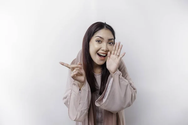 stock image Young beautiful Asian Muslim woman wearing a headscarf shouting and screaming loud with a hand on her mouth. communication concept.