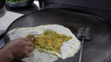 The process of making or cooking an Martabak Telur or Martabak Eggs, Indonesian street food. 