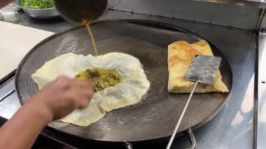 The process of making or cooking an Martabak Telur or Martabak Eggs, Indonesian street food. 