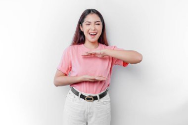 Gülümseyen genç Asyalı kadın, izole edilmiş arka planda duruyor. Avucunun içine bir reklam koymak için fotokopi alanı tutuyor.