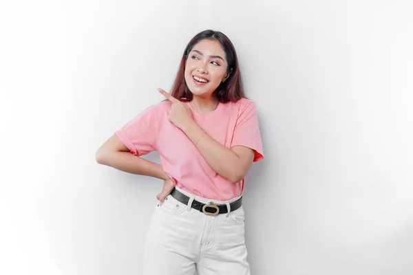 Aufgeregte Asiatin Trägt Rosa Shirt Und Zeigt Auf Den Kopierraum — Stockfoto