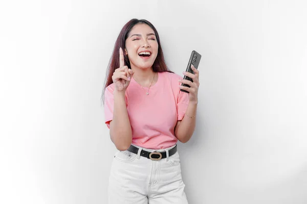 Portret Szczęśliwej Azjatki Różowej Koszulce Trzymającej Telefon Wskazującej Nią Przestrzenią — Zdjęcie stockowe