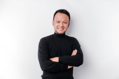 An Asian young confident man posing with crossed arm against a white background.
