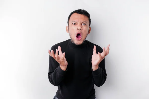 stock image The angry and mad face of Asian man in black shirt isolated white background.