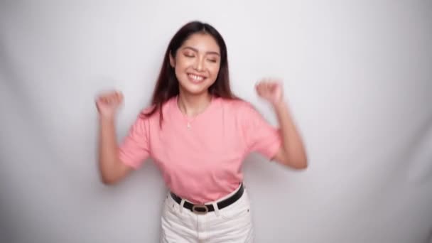 Menari Wanita Muda Yang Bahagia Mengenakan Kemeja Merah Muda Studio — Stok Video