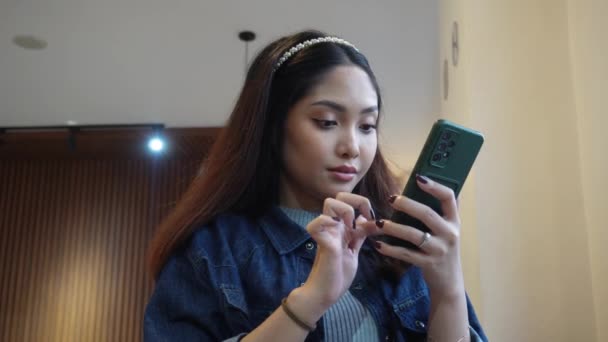 Aziatische Vrouw Zitten Een Cafe Terwijl Scrollen Haar Telefoon — Stockvideo