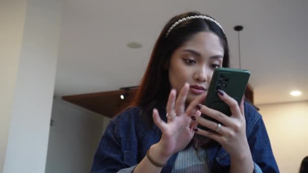 Aziatische Vrouw Zitten Een Cafe Terwijl Scrollen Haar Telefoon — Stockvideo