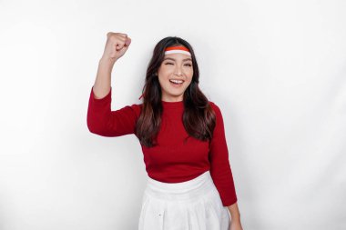 Kırmızı bluz ve beyaz arka planla izole edilmiş bantla mutlu ve başarılı bir yüz ifadesi olan genç bir Asyalı kadın. Endonezya 'nın bağımsızlık günü konsepti.