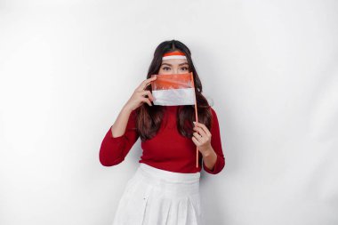 Endonezya 'nın Bağımsızlık Günü' nü kutlamak için elinde Endonezya bayrağı tutan mutlu gülümseyen Endonezyalı kadın beyaz arka planda izole edilmiş..