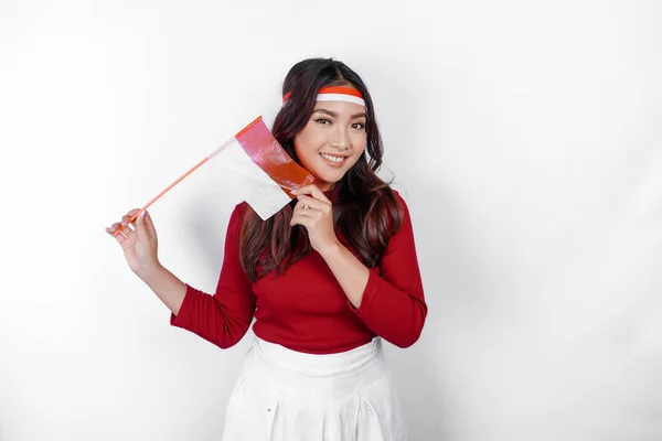 stock image Excited young Asian woman celebrate Indonesian independence day holding the Indonesian flag isolated on white background