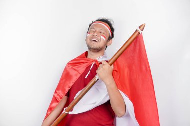Endonezya 'nın Bağımsızlık Günü' nü kutlamak için elinde Endonezya bayrağı tutan mutlu gülümseyen Endonezyalı adam beyaz arka planda izole edilmiş..