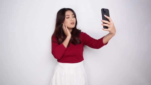 Elinde Telefonuyla Gülümseyen Asyalı Kadın Beyaz Arka Planla Selfie Çekiyor — Stok video