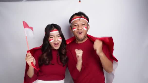 배경으로 인도네시아의 깃발을 들고있는 빨간색 상단과 밴드를 행복한 성공적인 표현을 — 비디오