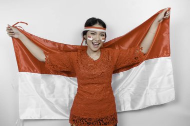 Endonezya Bağımsızlık Günü 'nü kutlamak için kırmızı kebaya ve saç bandı takan mutlu Endonezyalı kadın beyaz arka planda izole edilmiş..