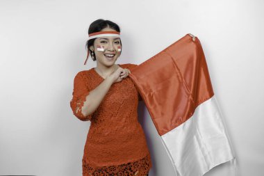 Endonezya Bağımsızlık Günü 'nü kutlamak için kırmızı kebaya ve saç bandı takan mutlu Endonezyalı kadın beyaz arka planda izole edilmiş..