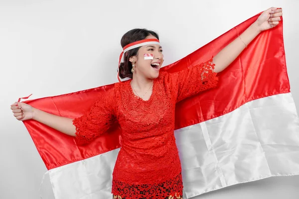 배경에 인도네시아 기념일을 축하하기 인도네시아의 깃발을 케바야와 밴드를 착용하는 행복한 — 스톡 사진