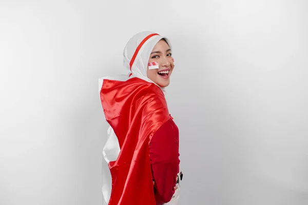インドネシア独立記念日を祝うためにインドネシアの旗を掲げた赤いトップと白いヒジャブを着たインドネシアのムスリム女性の笑顔 白い背景によって隔離される — ストック写真