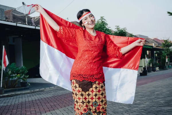 Szczęśliwa Uśmiechnięta Indonezyjska Kobieta Czerwonej Kebayi Trzymająca Flagę Indonezji Okazji — Zdjęcie stockowe