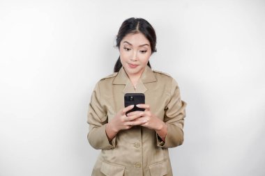 Gülümseyen devlet memuru kadın akıllı telefonunu tutuyor. Not: haki rengi üniforma giyiyor..