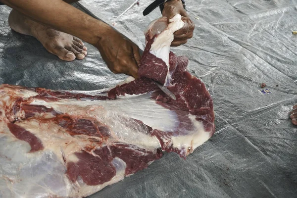 A portrait of Muslims cutting meat on Eid Al Adha by using cutting knife