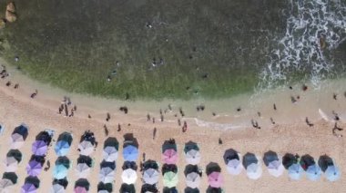 Şemsiyelerin, teknelerin ve Endonezya 'da tatil yapan insanların insansız hava aracı görüntüsü.