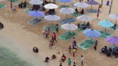 Şemsiyelerin, teknelerin ve Endonezya 'da tatil yapan insanların insansız hava aracı görüntüsü.