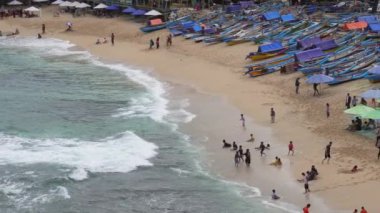 Şemsiyelerin, teknelerin ve Endonezya 'da tatil yapan insanların insansız hava aracı görüntüsü.