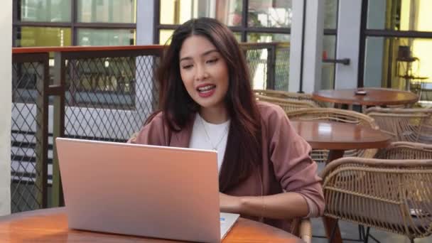 Досить Молода Азіатка Працює Віддалено Від Кафе Використовуючи Свій Ноутбук — стокове відео