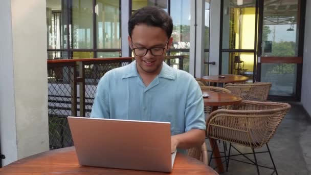 Bilgisayarını Kullanarak Uzaktan Çalışan Gülümseyen Asyalı Genç Adam Online Video — Stok video