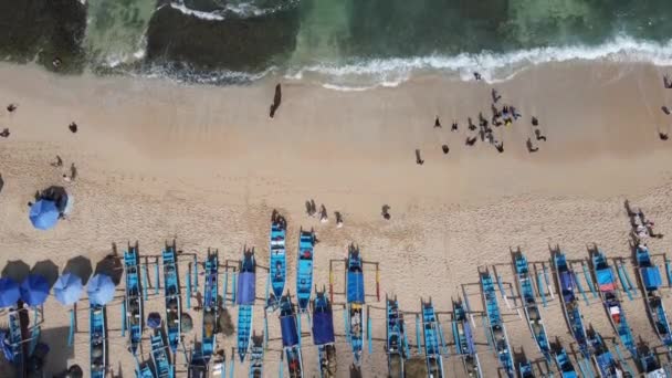 ジョグジャカルタ インドネシアのビーチで休暇を過ごす傘 ボート 人々の空中ドローンビュー — ストック動画