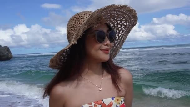 正午にビーチでチューブトップを着用するアジア女性のスローモーションフロントビュー 夏休みの女性観光客 — ストック動画