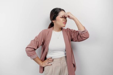 Üzgün bir Asyalı kadın çalışan hırka giyiyor, stresli ve depresif görünüyor, izole beyaz bir arka plan..