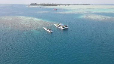 Karimunjawa, Coral Coast Çevre Koruma Alanı, Karimunjawa, Jepara, Endonezya 'daki resiflerin yakınındaki teknelerin hava görüntüsü..