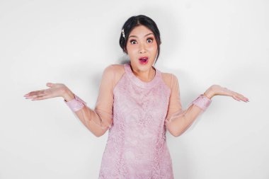 Şok olmuş Asyalı bir kadın ağzı açık ve yanındaki fotokopi alanını işaret ediyor, beyaz arka planla izole edilmiş..