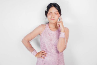 Pembe elbise giyen üzgün bir Asyalı kadın stresli ve depresif görünüyor..