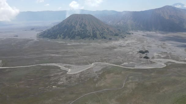 深いクレーターで活動する火山の空中観察 ブラウンは周りに汚れています インドネシア ブロモ山の火山における煙の雲 — ストック動画
