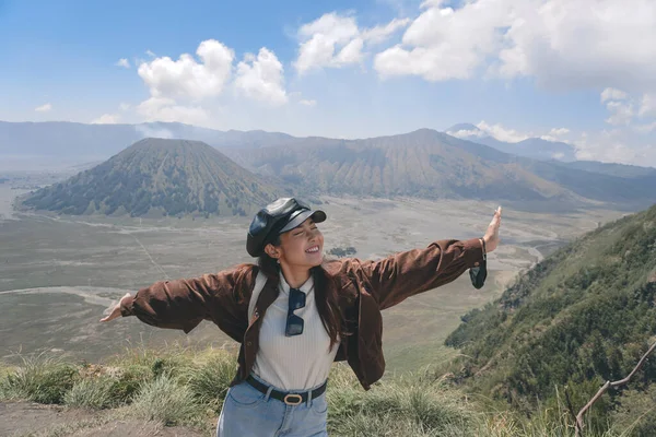 An Asian girl standing on a hill track in Bromo, enjoying view of Bromo, a wonderful scenery in dramatic hill