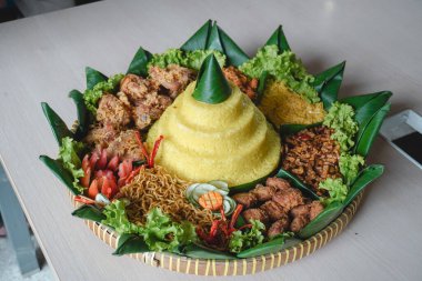 Nasi Tumpeng, beyaz arka planda izole edilmiş geleneksel Java yemekleri. Endonezya rijstafeli sarı pirinç. Bağımsızlık kutlamaları için ülkenin çeşitli bölgesel mutfaklarından mezeler..