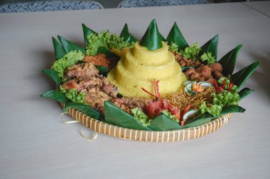 Nasi Tumpeng, beyaz arka planda izole edilmiş geleneksel Java yemekleri. Endonezya rijstafeli sarı pirinç. Bağımsızlık kutlamaları için ülkenin çeşitli bölgesel mutfaklarından mezeler..