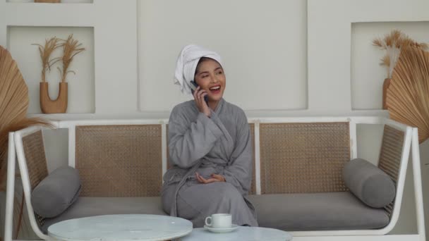 Radosny Uśmiechnięty Azjatka Kobieta Szarym Szlafroku Biały Ręcznik Głowie Siedzi Filmik Stockowy