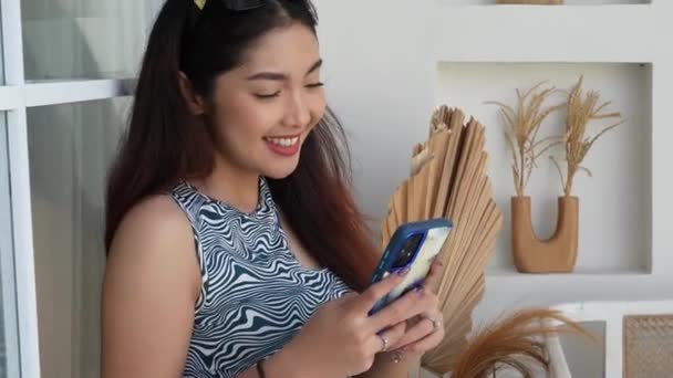 用智能手机装置检查社交媒体 在网上购买和订购产品 让年轻的亚洲女性笑逐颜开 假日生活方式概念 — 图库视频影像