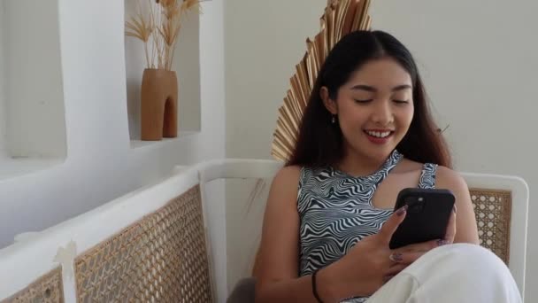 Heureuse Jeune Femme Asiatique Assise Sur Canapé Tout Utilisant Appareil — Video