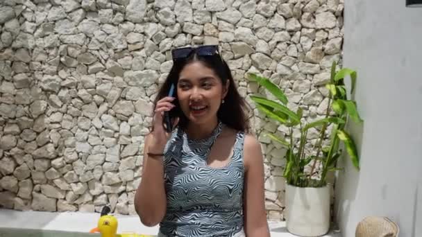 Indonesian Woman Wearing Pattern Sleeveless Top Smiling While Talking Phone Stock Video